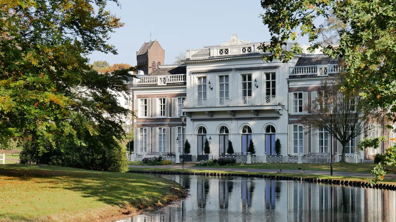 Statig wit huis aan een vijver in Arnhem