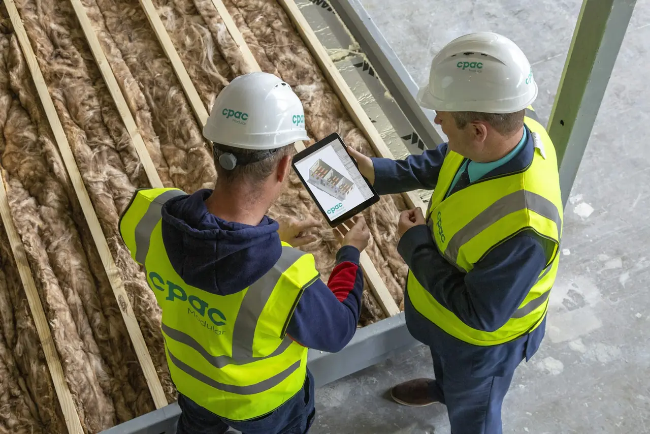 Twee vakmensen bekijken een plan op een tablet